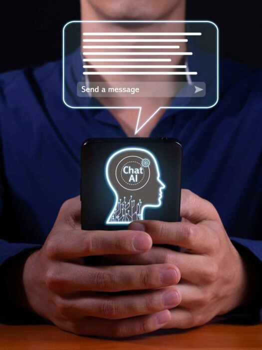 Man holding a smart phone with a chat icon on it