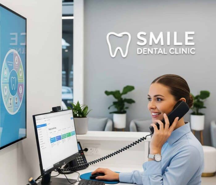 Efficient dental clinic receptionist using computer and phone at Smile Dental Clinic.