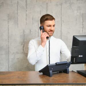 zoho bookings ai receptionist - Receptionist at desk in lobby