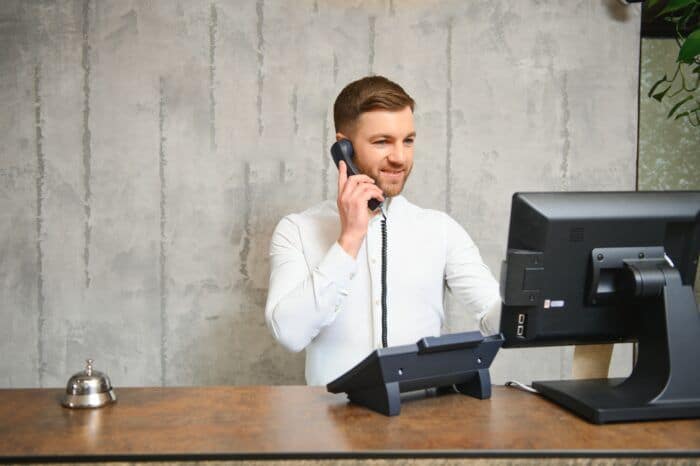 zoho bookings ai receptionist - Receptionist at desk in lobby