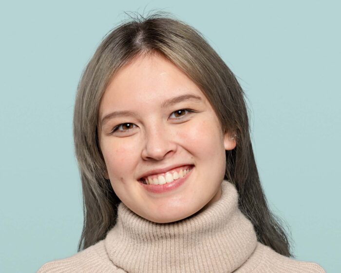 cheerful teenage girl smiling face portrait - Smiling woman in a beige turtleneck