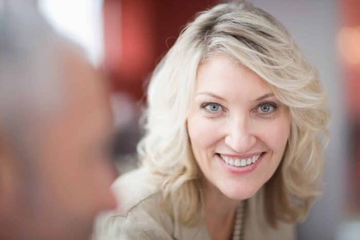 close businesswoman smiling face - Smiling businesswoman in a modern office
