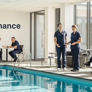 A professional team providing expert pool maintenance and cleaning services at a modern indoor pool facility.